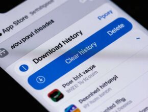 A close-up of a smartphone screen showing the App Store interface with a highlighted button that reads "Clear history" next to a title that says "Download history." This visually confirms the steps for "How to Delete App Download History."