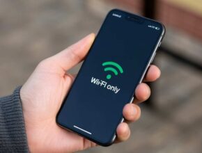 A person's hand holds an iPhone displaying a dark screen with a large green Wi-Fi symbol and the text "Wi-Fi only," indicating a setting that restricts downloads to Wi-Fi connections. This visually addresses the question, "How to Disable Download on WiFi Only iPhone."