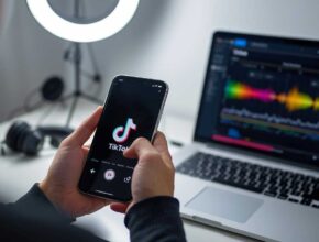 A person is holding a smartphone displaying the TikTok logo and interface, with a laptop in the background showing a bright, colorful audio or video editing waveform, suggesting the use of an external tool like AI for content creation. This image directly relates to "How to Use AI to Create TikTok Videos."